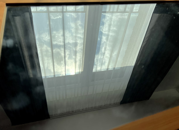 透过镜子从下面看黑白窗帘和天空。图片下载