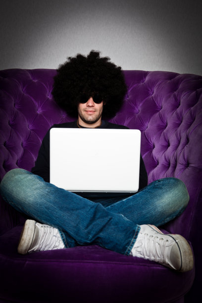 戴着非洲式假发和白色笔记本电脑的男人图片下载