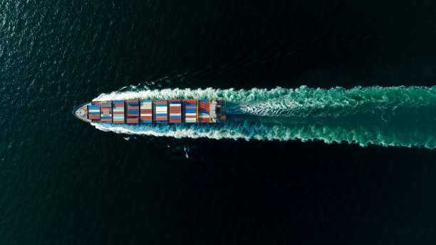 货运集装箱船在海上全速航行，进出口货物，并将产品分销给全球经销商和消费者，集装箱船运输业务交付服务，航拍视图图片下载