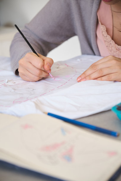 无法辨认的女人用丙烯颜料在衬衫上手绘图案。图片下载