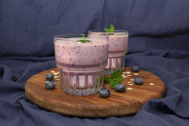 自制蓝莓冰沙与薄荷在蓝色织物背景。排毒饮食图片下载