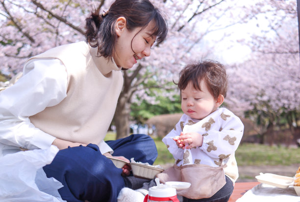 年轻的母子在樱花下吃午饭图片下载