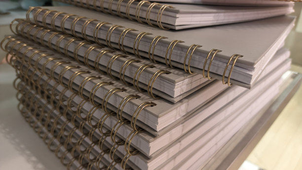 在一家廉价的家居用品商店里，有许多一模一样的笔记本一个摞着另一个图片下载