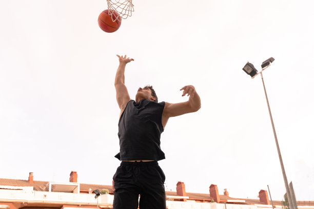 篮球运动员在一个夏天的下午表演扣篮。图片下载