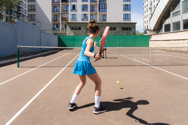 一个不知名的小女孩和一个不知名的十几岁的男孩在打网球图片下载