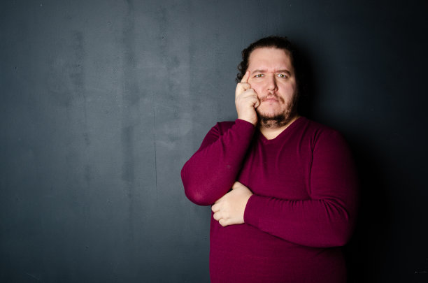 生意和工作。滑稽的胖子在摄影棚里摆姿势。图片下载