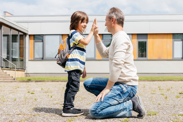 爸爸和儿子说再见或放学后在学校附近见面，给对方击掌图片下载