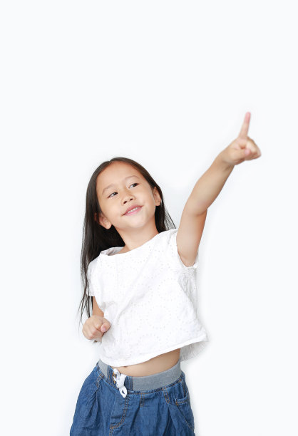肖像小女孩指向和仰望孤立的白色背景。图片下载