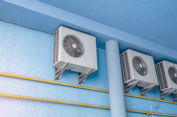蓝色墙壁上的白色空调。现代气候控制技术图片下载