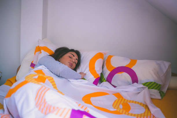 年轻女子早上在家躺在床上休息图片下载