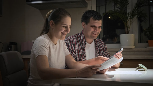 微笑的夫妇计算税款和每月的新房贷款。图片下载