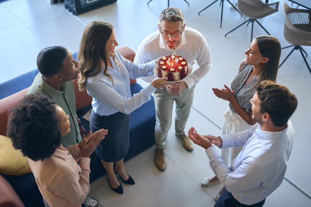 多元文化开放式办公室员工用蛋糕庆祝男同事生日图片下载