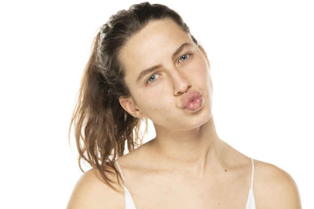 在白色的背景上，站着一幅美丽的年轻女子的肖像，她折叠着嘴唇等待着亲吻。图片下载