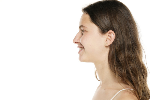 在白色背景上，一个面带微笑的年轻女子的侧面照图片下载