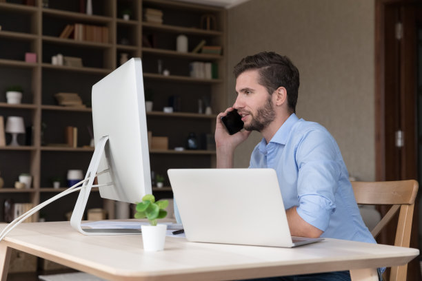 忙碌的年轻自由职业者在工作站打电话图片下载