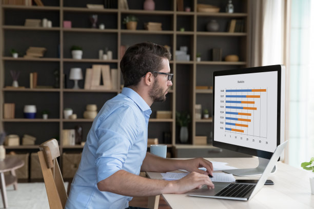 认真的年轻自由职业者分析商业图表图片下载