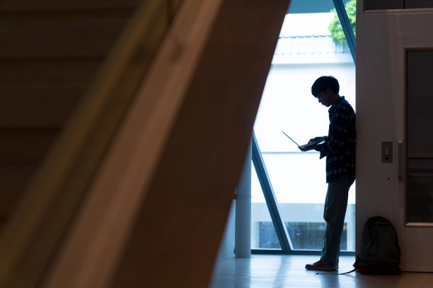 亚洲人在城市里用笔记本电脑工作的剪影。图片下载