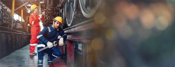 铁路工程师队伍穿着安全制服和安全帽，在列车，车轮和控制系统下进行安全旅行乘客的检查。横幅封面设计。图片下载