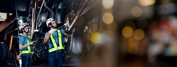 铁路工程师队伍穿着安全制服和安全帽，在列车，车轮和控制系统下进行安全旅行乘客的检查。横幅封面设计。图片下载