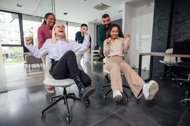 在现代办公室休息时，一群专业人士在椅子上赛跑图片下载