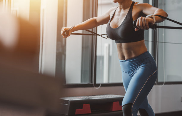 女子在健身房里多工位运动，既健康又强健。健身房健身运动图片下载