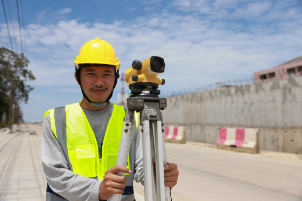 在建筑工地工作的男性工程师和测量设备。图片下载