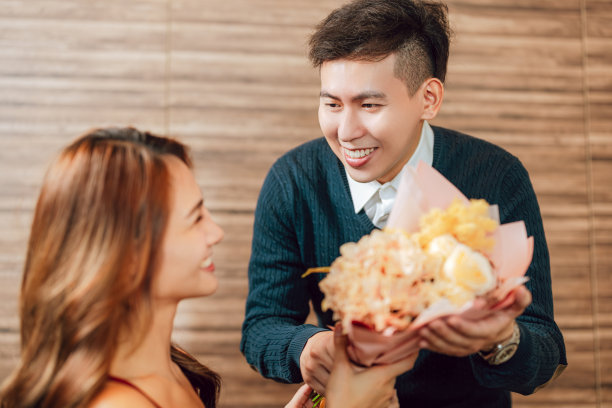 情人节那天，一个年轻人在餐馆里问候他的女朋友图片下载