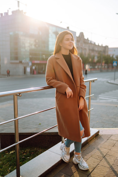 在一个阳光明媚的日子里，时尚的微笑女人漫步在城市里，享受着好天气。图片下载