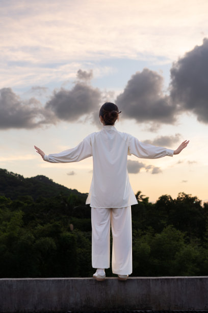 一位亚洲妇女正在公园里练习健身运动太极拳。图片下载