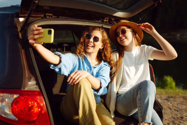 两个年轻女子在汽车旅行中享受大自然的乐趣。图片下载