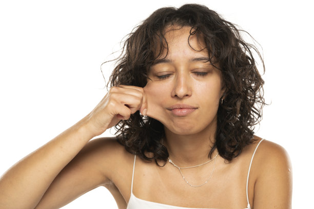 年轻的少数民族妇女的肖像，在白色的背景上拉着她的脸颊皮肤图片下载