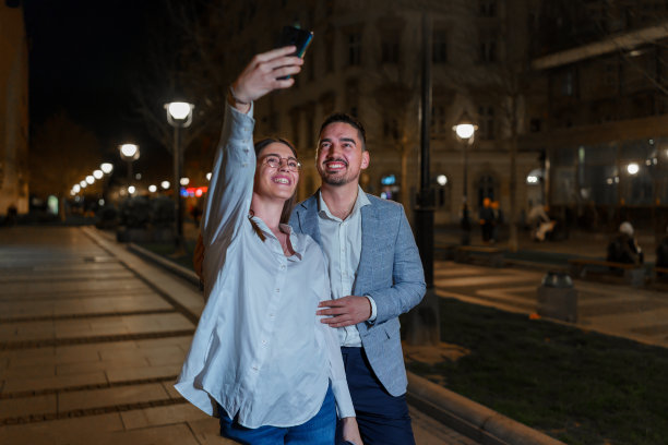 一对夫妇在城市街道上自拍，脸上洋溢着喜悦图片下载