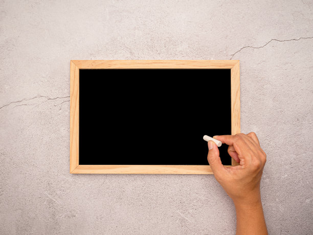 手里拿着粉笔，准备在小黑板上写点什么图片下载