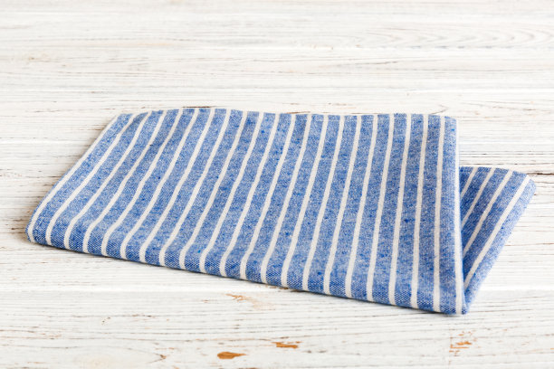 顶视图与蓝色厨房餐巾隔离在桌子背景。折叠布料与复制空间的模型，平铺。最小的风格图片下载