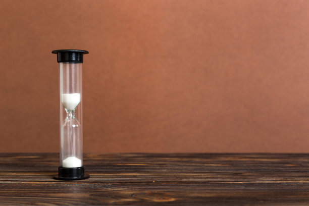 沙漏放在桌子上，沙钟作为时间流逝的概念，为业务的最后期限，复制空间图片下载