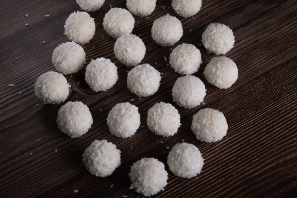 甜点的照片，白色的椰子屑圆形糖果放在木桌上图片下载