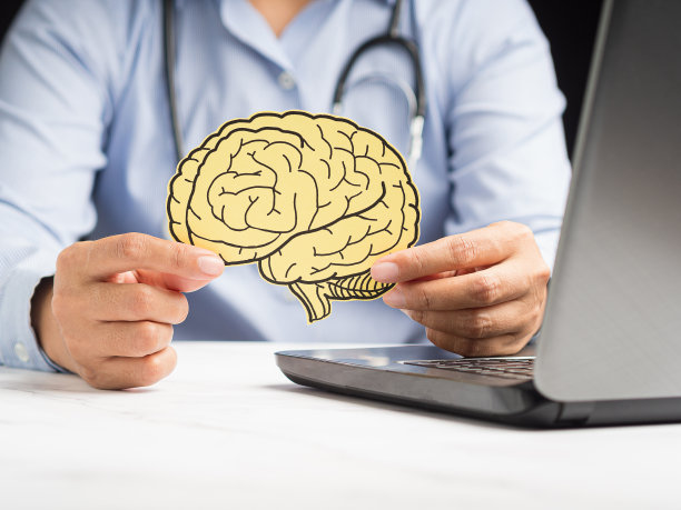 医生坐在医院里，手里拿着一个黄纸做的大脑模型图片下载