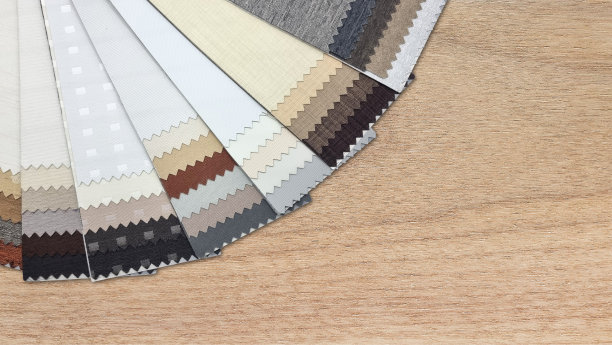 大地色调中不同质感的黑色布料样品，近距离观察，放置在橡木木桌上，留白设计。图片下载