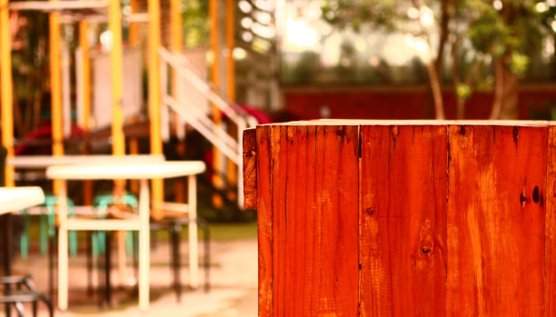 木桌在前面的模糊美丽的绿色公园背景图片下载