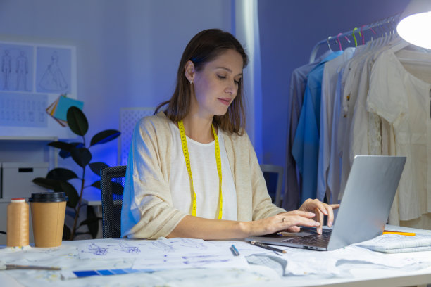加班到很晚的年轻设计师们正在为小型服装企业设计夏季时装。图片下载