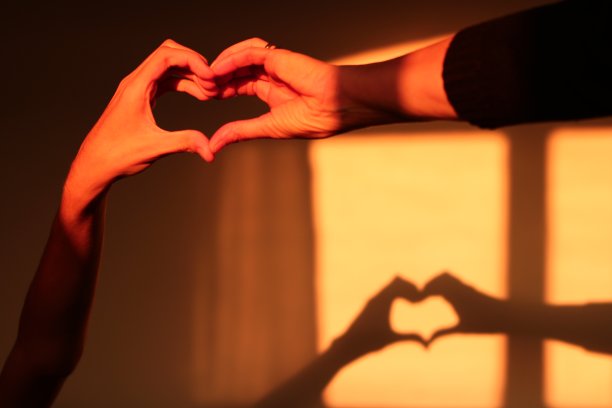 母亲和儿子在墙上形成心形的影子图片下载