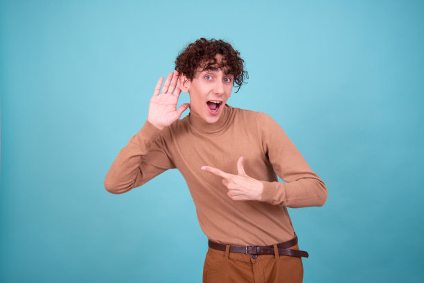 情绪化的家伙在蓝色背景的工作室里摆姿势，既惊讶，又高兴，又悲伤。图片下载