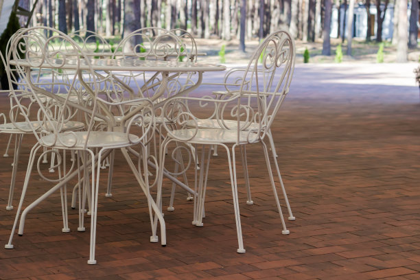 夏日咖啡馆里的白色金属桌椅图片下载