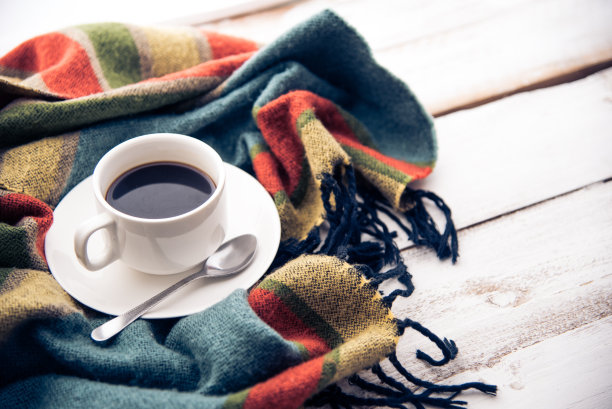 咖啡杯和围巾放在白色的木地板上。图片下载