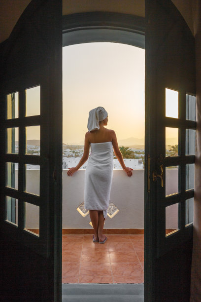 这个女孩站在阳台上看山上的日落图片下载