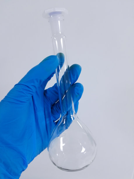 用戴着手套的白底手拿着孤立的体积瓶图片下载