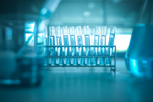 蓝色滴入玻璃烧杯与烧瓶和科学实验室的背景图片下载