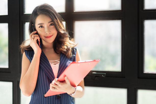 自信的女人靠窗站着。图片下载