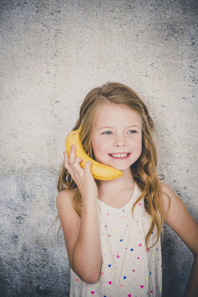 金发美女在演播室里和香蕉通电话图片下载