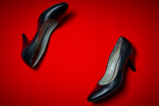 红色背景上的一双黑色高跟鞋图片下载